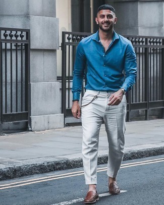 Comment porter une chemise de ville bleue: Pense à porter une chemise de ville bleue et un pantalon de costume blanc pour un look classique et élégant. Tu veux y aller doucement avec les chaussures? Choisis une paire de slippers en cuir tressés marron pour la journée.