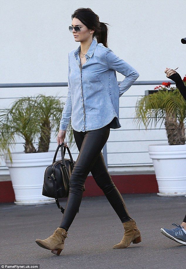 Looking glamorous in skinny jeans with black pumps and a denim shirt, 