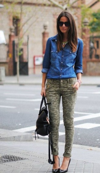 Tenue: Chemise en jean bleue, Pantalon slim camouflage olive, Escarpins en cuir noirs, Sac à dos en cuir noir