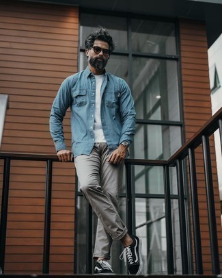 Comment porter un jean gris: Opte pour une chemise en jean bleu clair avec un jean gris pour affronter sans effort les défis que la journée te réserve. Cette tenue se complète parfaitement avec une paire de baskets basses en toile noires et blanches.