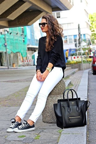 Comment porter des baskets basses noires et blanches: Opte pour un chemisier à manches longues noir avec un jean skinny blanc pour obtenir un look relax mais stylé. Une paire de baskets basses noires et blanches apporte une touche de décontraction à l'ensemble.