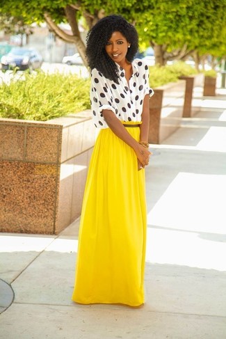 Comment porter une jupe longue plissée jaune: Associe un chemisier boutonné á pois blanc et noir avec une jupe longue plissée jaune pour un look de tous les jours facile à porter.