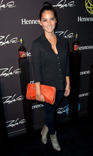 Tenue de Olivia Munn: Chemisier boutonné noir, Pantalon slim noir, Bottines en cuir grises, Pochette en cuir orange