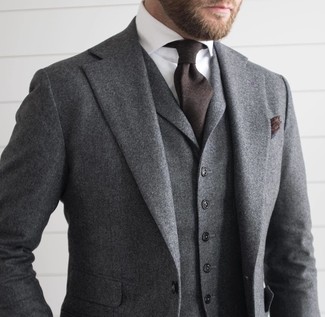 Comment porter un costume en laine gris foncé: Opte pour un costume en laine gris foncé avec une chemise de ville blanche pour un look classique et élégant.