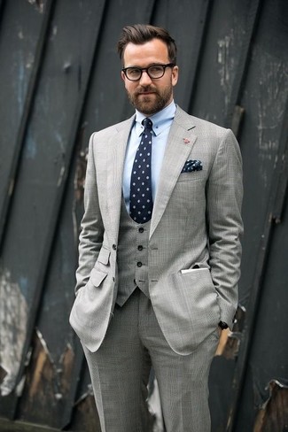 Comment porter une cravate imprimée bleu marine et blanc: Pense à harmoniser un complet gris avec une cravate imprimée bleu marine et blanc pour une silhouette classique et raffinée.