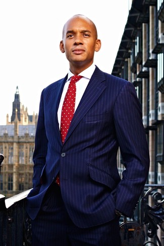 Comment porter une cravate á pois rouge: Associe un costume à rayures verticales bleu marine avec une cravate á pois rouge pour un look classique et élégant.