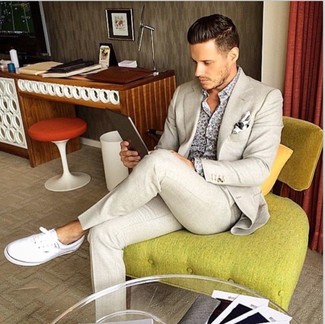 Un costume à porter avec des baskets basses blanches pour un style chic decontractés: Choisis un costume et une chemise à manches longues imprimée grise pour une silhouette classique et raffinée. Pour les chaussures, fais un choix décontracté avec une paire de baskets basses blanches.