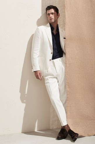 Comment porter un costume blanc: Fais l'expérience d'un style élégant et raffiné avec un costume blanc et une chemise à manches longues bleu marine. Complète ce look avec une paire de chaussures derby en cuir marron foncé.