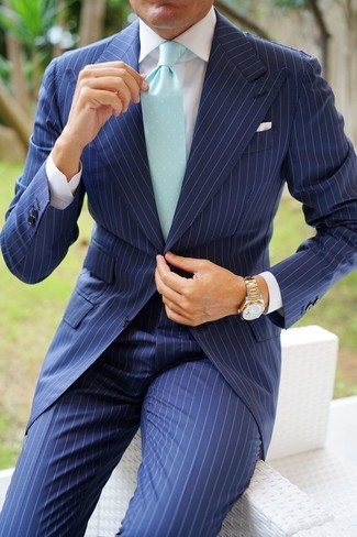 Comment porter une cravate verte quand il fait chaud: Pense à porter un costume à rayures verticales bleu marine et une cravate verte pour dégager classe et sophistication.