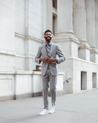 Comment porter une cravate à rayures horizontales gris foncé: Choisis un costume gris et une cravate à rayures horizontales gris foncé pour un look classique et élégant. Une paire de baskets basses en toile blanches apporte une touche de décontraction à l'ensemble.