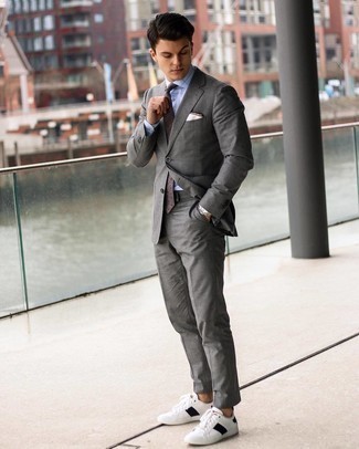 Comment porter une cravate imprimée pour un style chic decontractés: Opte pour un costume gris avec une cravate imprimée pour dégager classe et sophistication. Si tu veux éviter un look trop formel, termine ce look avec une paire de baskets basses en cuir blanches et noires.