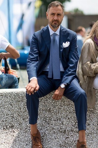 Comment porter une cravate bleue: Choisis un costume bleu marine et une cravate bleue pour un look pointu et élégant. Une paire de bottines chukka en cuir marron apporte une touche de décontraction à l'ensemble.