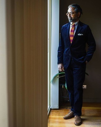 Comment porter une cravate multicolore après 50 ans: Associe un costume en velours côtelé bleu marine avec une cravate multicolore pour un look pointu et élégant. Une paire de bottines chukka en daim marron apporte une touche de décontraction à l'ensemble.