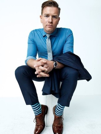 Tenue de Ewan McGregor: Costume bleu marine, Chemise de ville en chambray bleue, Chaussures brogues en cuir marron, Cravate grise