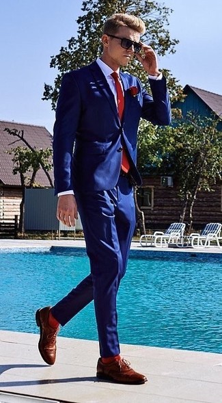 Comment porter une cravate rouge en été: Essaie d'harmoniser un costume bleu marine avec une cravate rouge pour dégager classe et sophistication. Tu veux y aller doucement avec les chaussures? Fais d'une paire de chaussures brogues en cuir marron ton choix de souliers pour la journée. Nous sommes tombés dingue de cette tenue qui sent bon l'été.