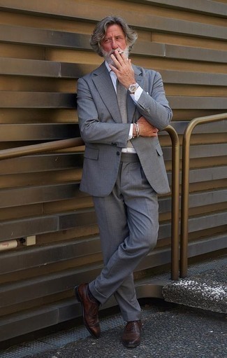 Comment porter une cravate grise après 60 ans: Harmonise un costume gris avec une cravate grise pour dégager classe et sophistication. Décoince cette tenue avec une paire de chaussures brogues en cuir marron foncé.
