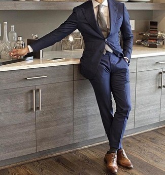 Comment porter une cravate grise pour un style elégantes: Fais l'expérience d'un style classique avec un costume bleu marine et une cravate grise. Jouez la carte décontractée pour les chaussures et termine ce look avec une paire de chaussures brogues en cuir marron clair.