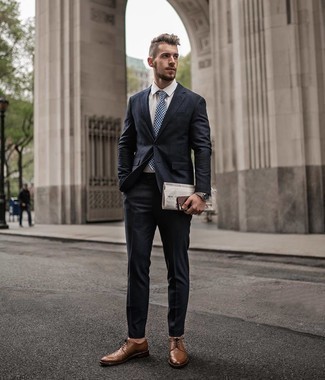 Comment porter une cravate blanc et bleu marine à 30 ans: Pense à marier un costume bleu marine avec une cravate blanc et bleu marine pour dégager classe et sophistication. Une paire de chaussures brogues en cuir marron apporte une touche de décontraction à l'ensemble.