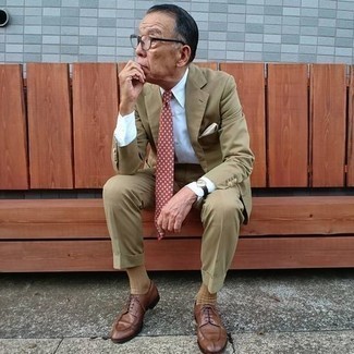 Comment porter une cravate á pois marron après 60 ans: Associe un costume marron clair avec une cravate á pois marron pour dégager classe et sophistication. Tu veux y aller doucement avec les chaussures? Fais d'une paire de chaussures derby en cuir marron ton choix de souliers pour la journée.