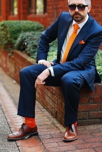 Comment porter une pochette de costume en soie orange: Associe un costume bleu marine avec une pochette de costume en soie orange pour affronter sans effort les défis que la journée te réserve. Choisis une paire de chaussures richelieu en cuir marron pour afficher ton expertise vestimentaire.