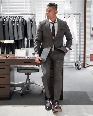 Comment porter une cravate imprimée noire pour un style elégantes en été: Pense à porter un costume gris foncé et une cravate imprimée noire pour un look classique et élégant. Si tu veux éviter un look trop formel, opte pour une paire de chaussures richelieu en cuir noires. Ce look est juste canon et parfait pour l'été.