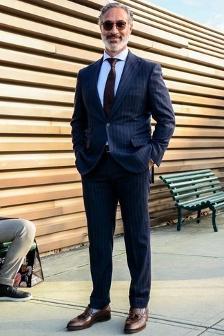 Comment porter une cravate marron après 50 ans: Pense à associer un costume à rayures verticales bleu marine avec une cravate marron pour une silhouette classique et raffinée. Pour les chaussures, fais un choix décontracté avec une paire de mocassins à pampilles en cuir marron.