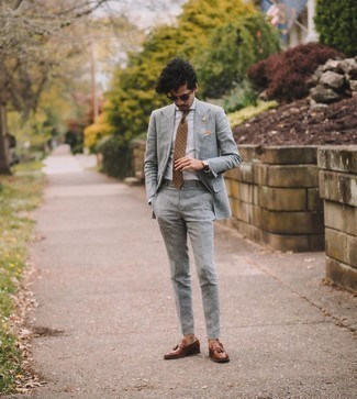 Comment porter une cravate imprimée beige: Associe un costume gris avec une cravate imprimée beige pour un look pointu et élégant. Jouez la carte décontractée pour les chaussures et assortis cette tenue avec une paire de mocassins à pampilles en cuir marron.