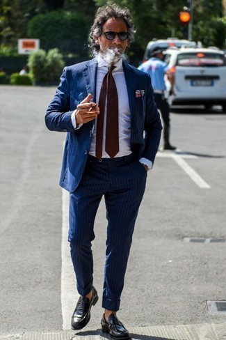 Comment porter une cravate pour un style elégantes après 40 ans: Essaie d'harmoniser un costume à rayures verticales bleu marine avec une cravate pour une silhouette classique et raffinée. Pourquoi ne pas ajouter une paire de slippers en cuir noirs à l'ensemble pour une allure plus décontractée?