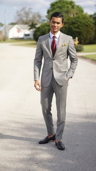 Comment porter une cravate rouge: Opte pour un costume gris avec une cravate rouge pour un look classique et élégant. Jouez la carte décontractée pour les chaussures et complète cet ensemble avec une paire de slippers en cuir noirs.