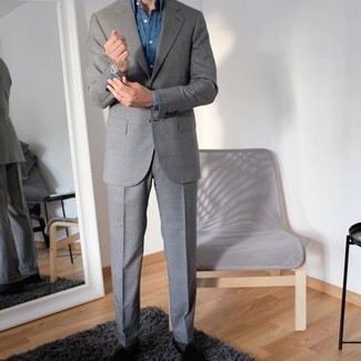 Comment porter des slippers en velours noirs à 30 ans: Pense à associer un costume gris avec une chemise de ville en chambray bleue pour dégager classe et sophistication. Si tu veux éviter un look trop formel, termine ce look avec une paire de slippers en velours noirs.
