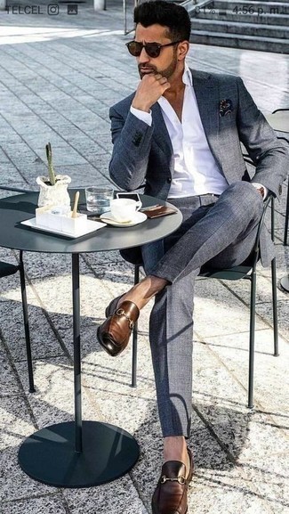 Comment porter un costume gris avec des slippers en cuir marron à 30 ans: Pense à marier un costume gris avec une chemise de ville blanche pour un look pointu et élégant. Une paire de slippers en cuir marron apporte une touche de décontraction à l'ensemble.