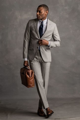 Comment porter une cravate en soie bleu marine: Pense à opter pour un costume gris et une cravate en soie bleu marine pour dégager classe et sophistication. Tu veux y aller doucement avec les chaussures? Termine ce look avec une paire de slippers en cuir marron pour la journée.