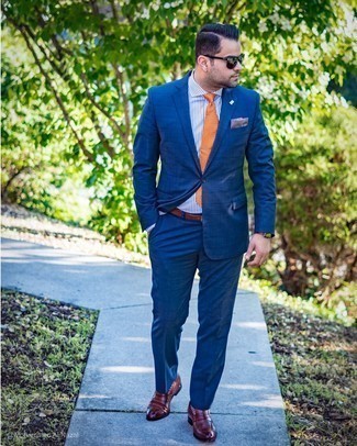 Comment porter une cravate imprimée orange: Pense à harmoniser un costume à carreaux bleu marine avec une cravate imprimée orange pour un look classique et élégant. Une paire de slippers en cuir marron foncé apporte une touche de décontraction à l'ensemble.