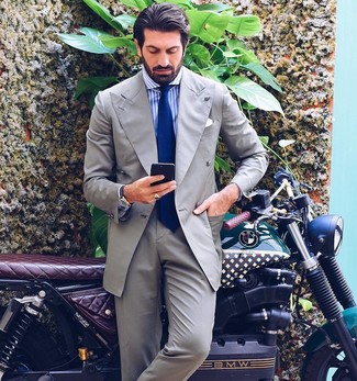 Comment porter une cravate bleue: Associe un costume gris avec une cravate bleue pour dégager classe et sophistication.