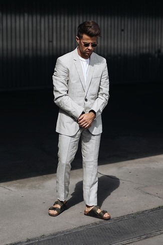 Comment porter un costume en lin gris: Harmonise un costume en lin gris avec un t-shirt à col rond blanc pour aller au bureau. Si tu veux éviter un look trop formel, fais d'une paire de sandales en cuir vert foncé ton choix de souliers.