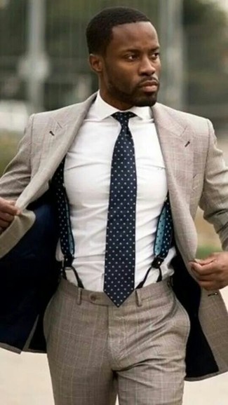 Comment porter une cravate á pois bleu marine et blanc: Essaie d'harmoniser un costume marron clair avec une cravate á pois bleu marine et blanc pour une silhouette classique et raffinée.