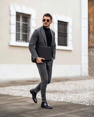 Comment porter un costume en laine gris foncé: Pense à porter un costume en laine gris foncé et un pull à col roulé noir pour un look pointu et élégant. Une paire de bottines chelsea en cuir noires est une option parfait pour complèter cette tenue.