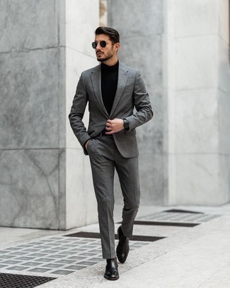 Comment porter un costume gris quand il fait chaud à 20 ans: Associe un costume gris avec un pull à col roulé noir pour une silhouette classique et raffinée. Cette tenue se complète parfaitement avec une paire de bottines chelsea en cuir noires.