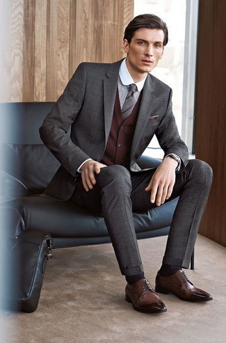 Comment porter une cravate argentée: Harmonise un costume à carreaux gris foncé avec une cravate argentée pour un look classique et élégant. Une paire de chaussures brogues en cuir marron apporte une touche de décontraction à l'ensemble.