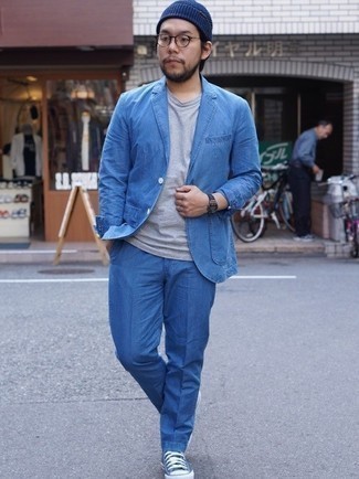 Comment porter un costume bleu: Essaie d'associer un costume bleu avec un t-shirt à col rond gris pour un look idéal au travail. Tu veux y aller doucement avec les chaussures? Choisis une paire de baskets basses en toile bleues pour la journée.