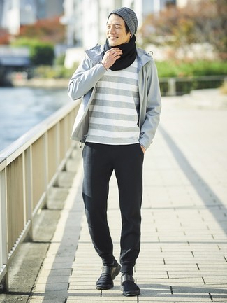 Tenue: Coupe-vent gris, T-shirt à col rond à rayures horizontales gris, Pantalon de jogging noir, Chaussures de sport noires