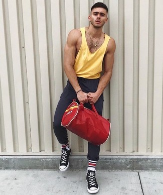 Tenue: Débardeur jaune, Pantalon de jogging gris foncé, Baskets montantes en toile noires, Grand sac en toile rouge