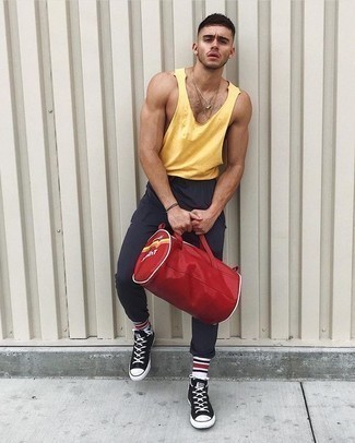 Tenue: Débardeur jaune, Pantalon de jogging gris foncé, Baskets montantes en toile noires et blanches, Grand sac en toile rouge