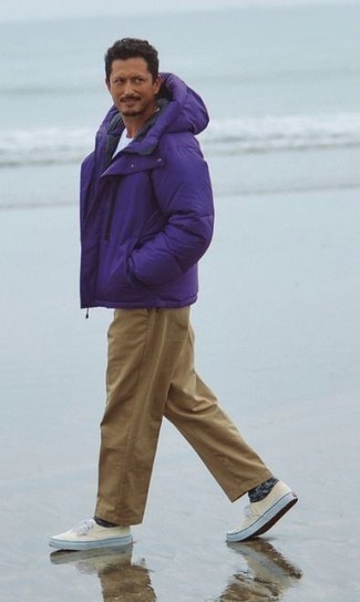 Comment porter des baskets basses en toile beiges: Opte pour une doudoune violette avec un pantalon chino marron clair pour prendre un verre après le travail. Si tu veux éviter un look trop formel, fais d'une paire de baskets basses en toile beiges ton choix de souliers.