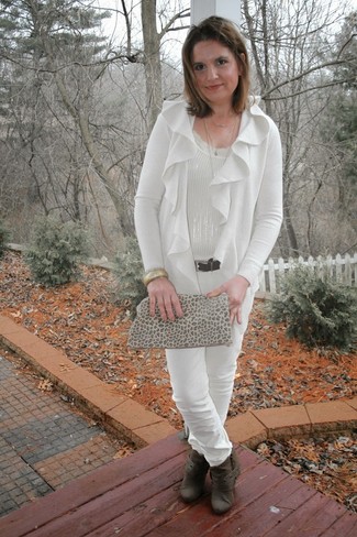 Comment s'habiller après 50 ans: Pense à harmoniser un gilet blanc avec un pantalon slim blanc et tu auras l'air d'une vraie poupée. Termine ce look avec une paire de des bottines en cuir marron foncé.