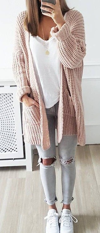 Comment porter un gilet en tricot rose: Marie un gilet en tricot rose avec un jean skinny déchiré gris pour créer un look génial et idéal le week-end. Termine ce look avec une paire de baskets basses en cuir blanches.