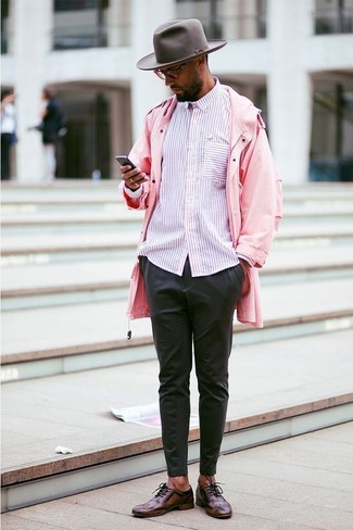 Tenue: Imperméable rose, Chemise à manches longues à rayures verticales rose, Pantalon chino noir, Chaussures richelieu en cuir marron foncé