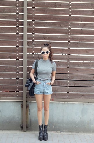 Comment porter un short en denim bleu clair avec des bottines en cuir noires