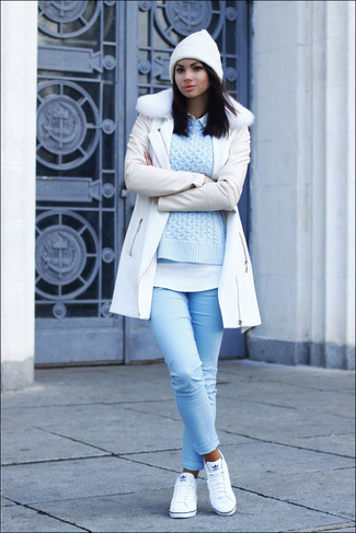 Comment porter un jean skinny bleu clair en automne: Opte pour un manteau à col fourrure blanc avec un jean skinny bleu clair pour une tenue raffinée mais idéale le week-end. Jouez la carte décontractée pour les chaussures et fais d'une paire de baskets basses blanches ton choix de souliers. La tenue est plutôt automnale.