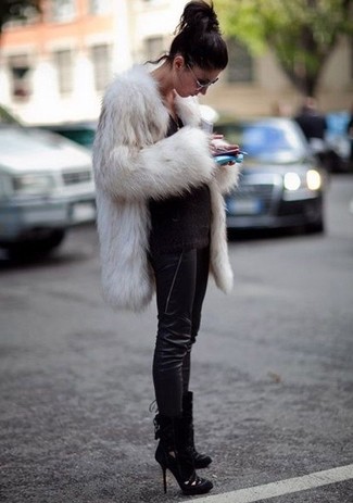 Comment s'habiller en hiver: Marie un manteau de fourrure blanc avec un pantalon slim en cuir noir pour créer un look chic et décontracté. Une paire de bottines en daim découpées noires est une option avisé pour complèter cette tenue. Un look superbe pour bien démarrer l'hiver.